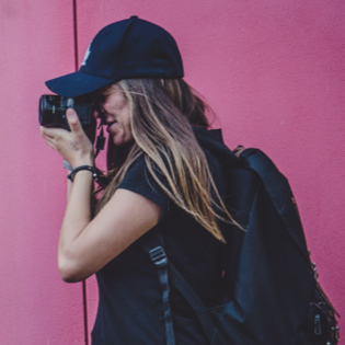 side profile of woman holding a camera up to her face